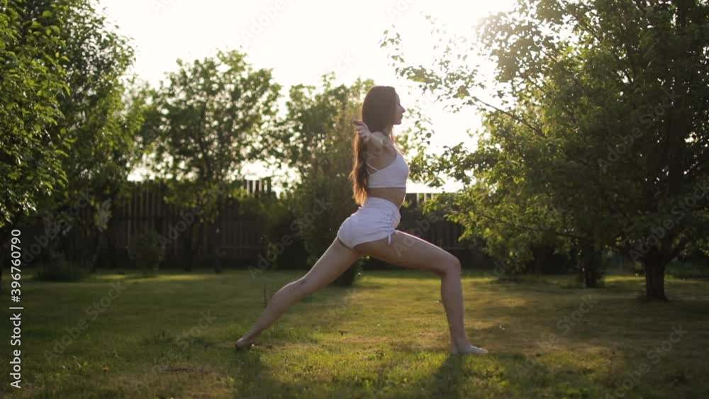 Young woman practicing yoga at sunrise in the garden Young woman practicing yoga at sunrise in the garden