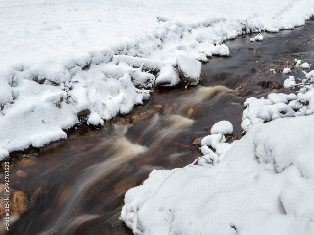 Winter mountain stream in Karelia flows through the forest. The power of wild majestic nature. Water turbulence. Winter mountain stream in Karelia flows through the forest. The power of wild majestic nature. Water turbulence.