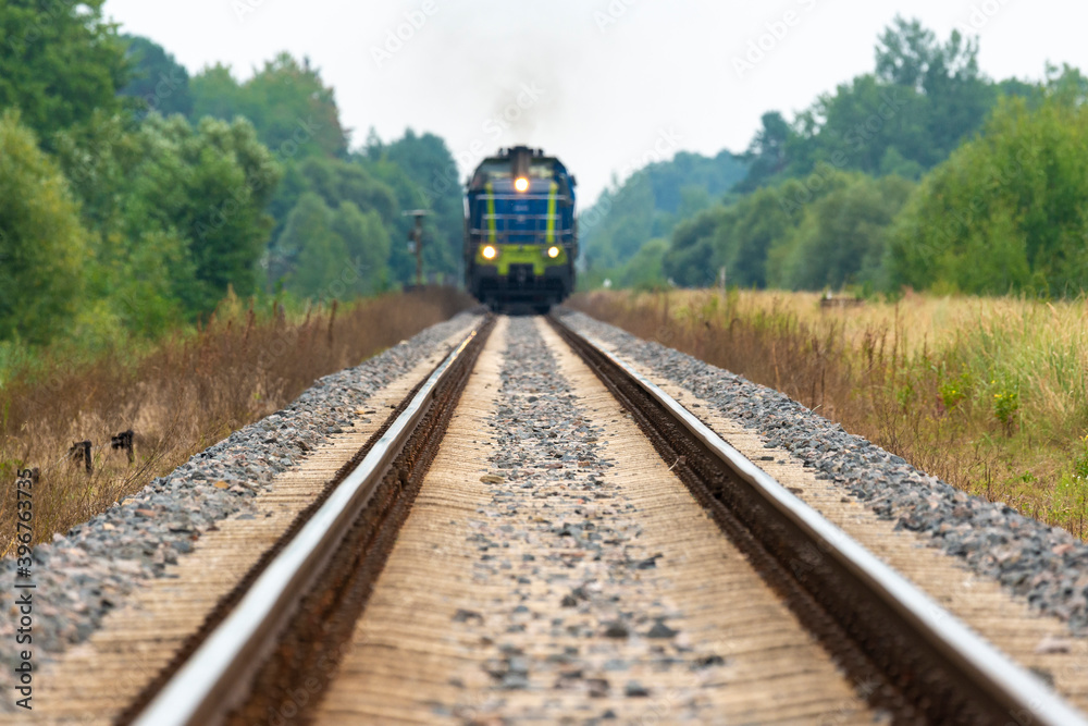 Fototapeta premium On the tracks, an approaching train to cross