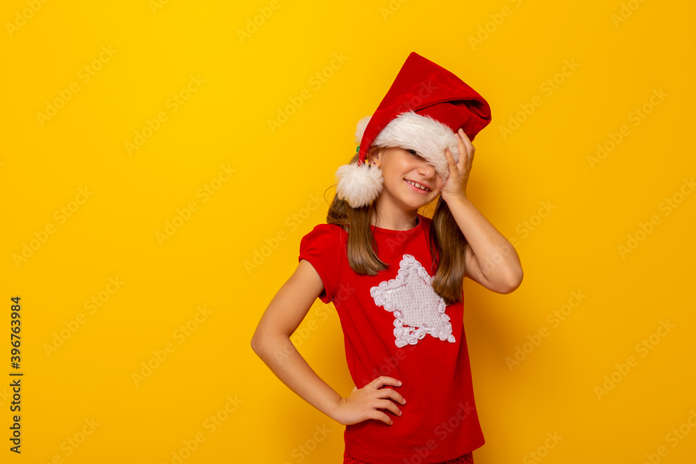 Child wearing Santa hat holding head in hands Child wearing Santa hat holding head in hands
