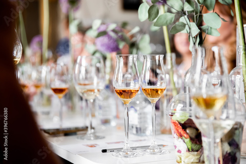 Tasting strong alcoholic drinks from beautiful glasses in a well-lit room with fresh flowers