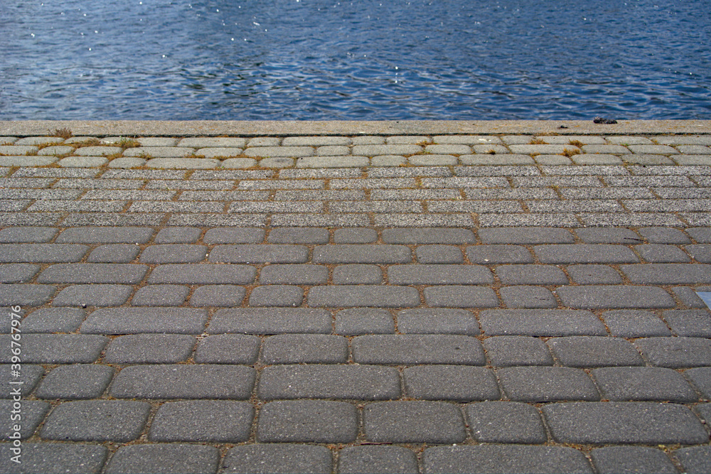 A cobbled floor next to a body of water