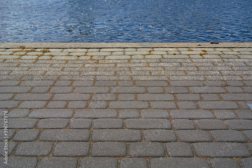 Obraz na płótnie A cobbled floor next to a body of water w salonie