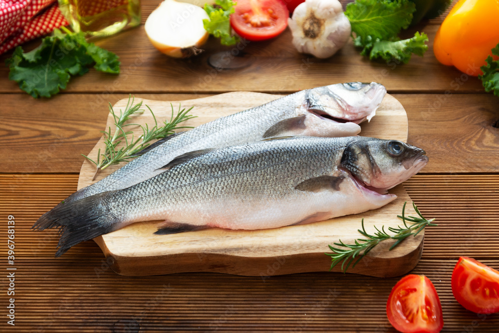 Seabass fish isolated on wooden background, top view. Seabass fish isolated on wooden background, top view.