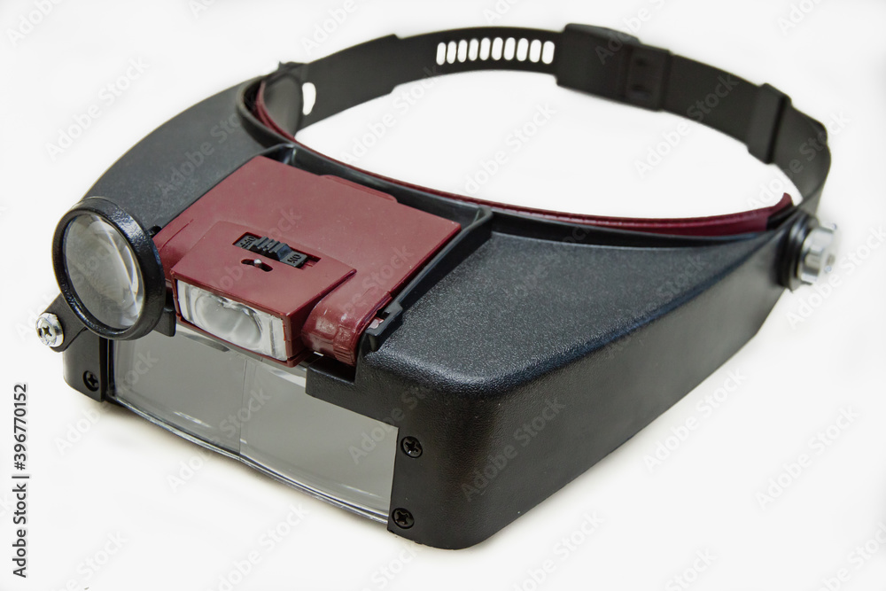 Glasses-magnifier with led illumination with a head mount. Isolated Glasses-magnifier with led illumination with a head mount. Isolated