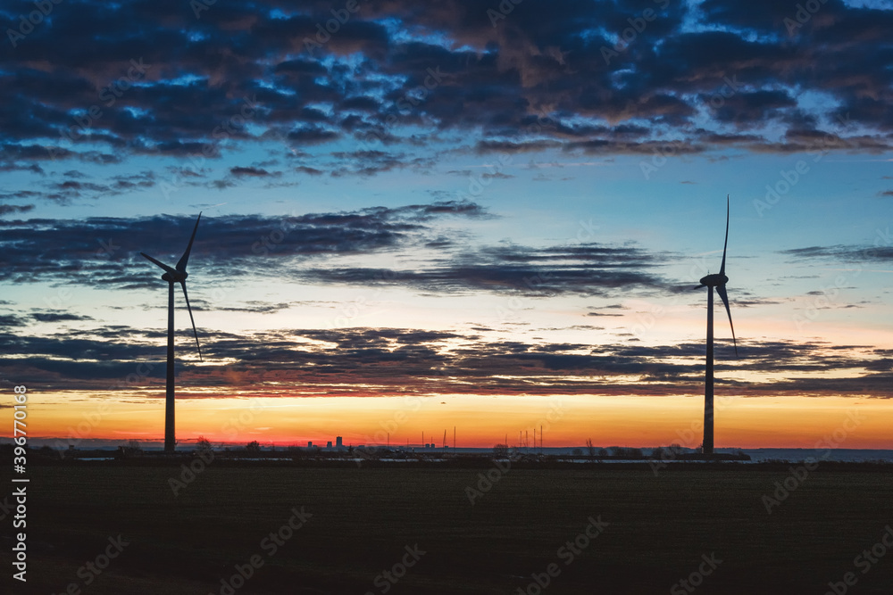 Obraz premium Two large windmills on the shore of the lake Markermeer during sunrise
