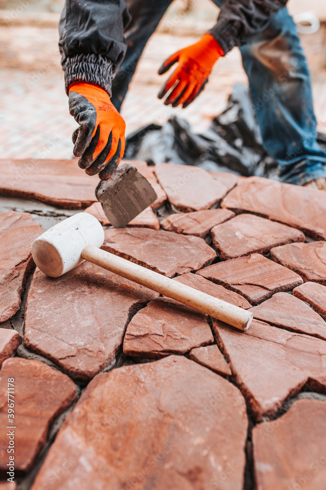 Laying tiles on the floor outside the house - professional tiling during work - decor with stone Laying tiles on the floor outside the house - professional tiling during work - decor with stone
