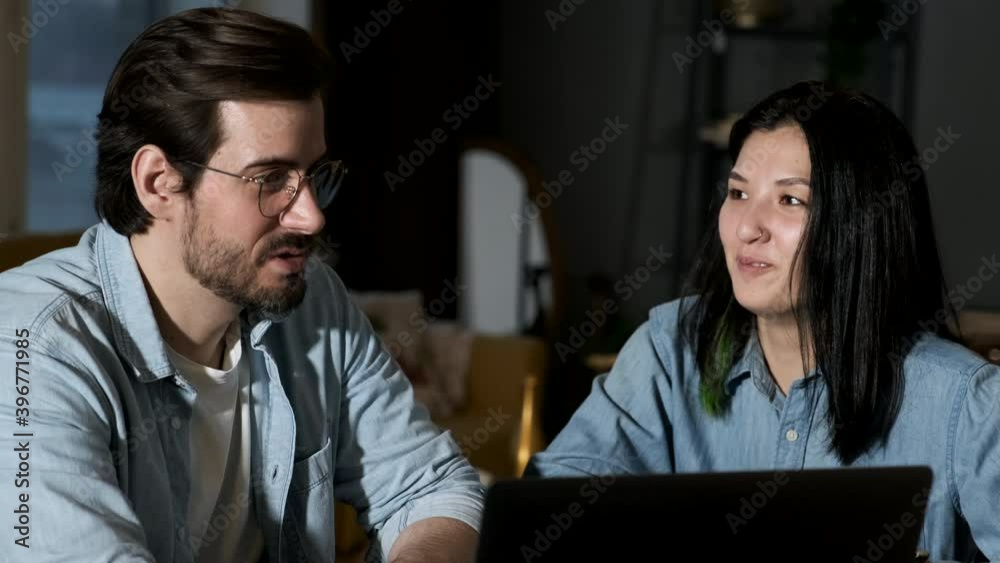 Close up portrait young couple sitting in front of a notebook at home. Handsome brunette man and cute woman working at laptop. Close up portrait young couple sitting in front of a notebook at home. Handsome brunette man and cute woman working at laptop.
