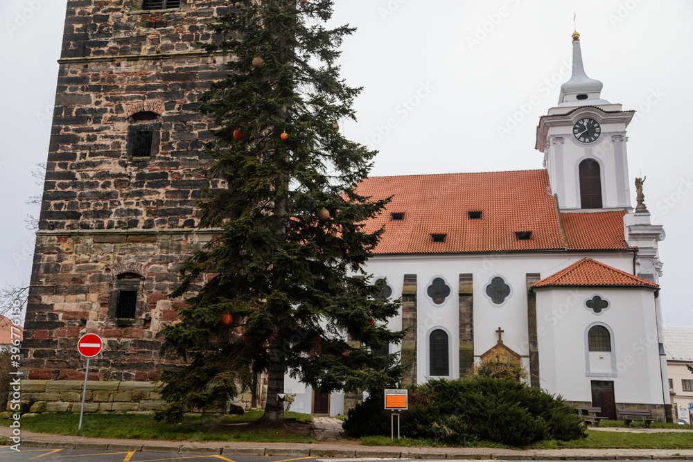 Gothic medieval stone bell tower and baroque saint Gothard church in old historic center of Cesky Brod, Christmas tree and Christmas decorations, Central Bohemia, Czech Republic