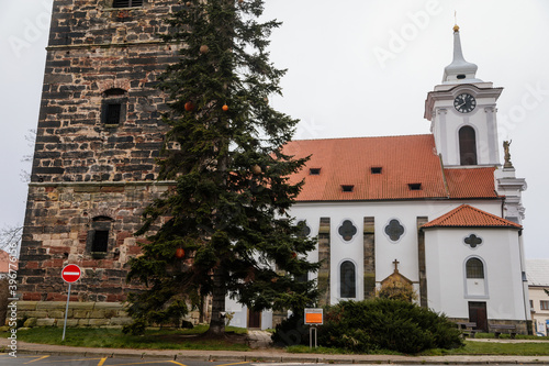 Gothic medieval stone bell tower and baroque saint Gothard church in old historic center of Cesky Brod, Christmas tree and Christmas decorations, Central Bohemia, Czech Republic photo