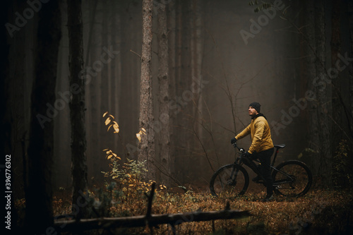 Wallpaper Mural Young man taking a brake during biking through autumn forest Torontodigital.ca