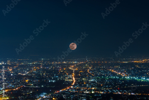the Last Penumbral Lunar Eclipse in 2020 over Chiang mai city at night , multiple exposure photo