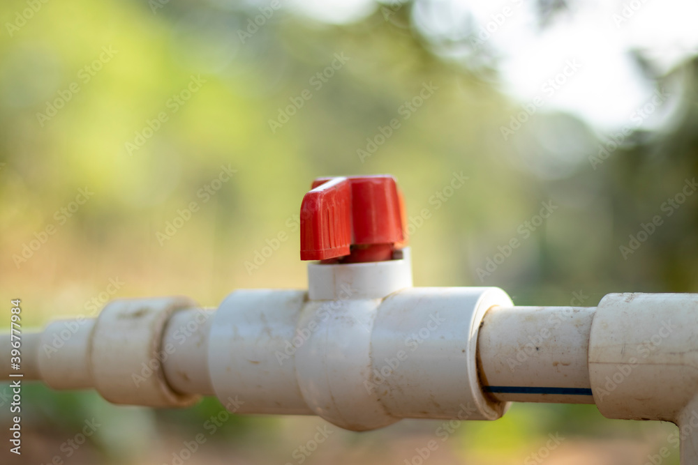 Red switch on white plastic water pipeline Red switch on white plastic water pipeline