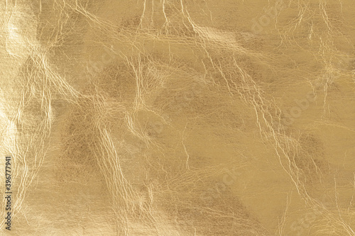 Cracked golden color foil leather texture as background