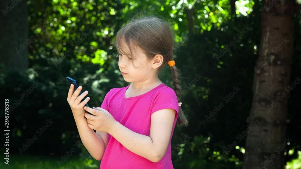 Young little child doing a video call using her smartphone, mobile phone. Girl, kid holding her cellphone using the front camera to show her surroundings, take pictures. Kids and technology concept Young little child doing a video call using her smartphone, mobile phone. Girl, kid holding her cellphone using the front camera to show her surroundings, take pictures. Kids and technology concept