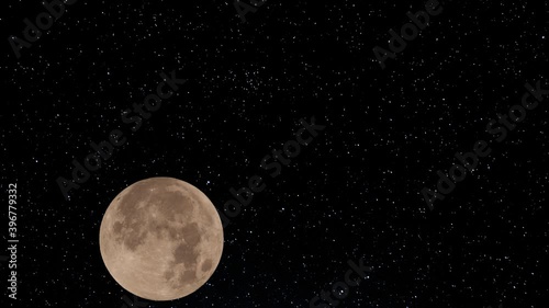 The moon rising across a starry night sky photo