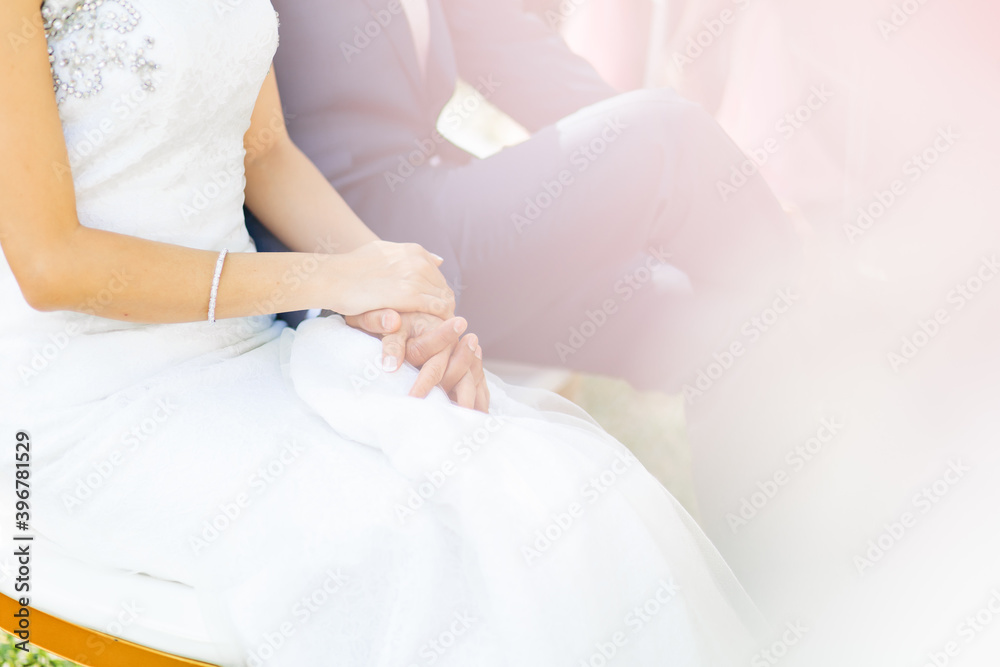 Close up of the hands of the bride being held tightly by the groom Close up of the hands of the bride being held tightly by the groom