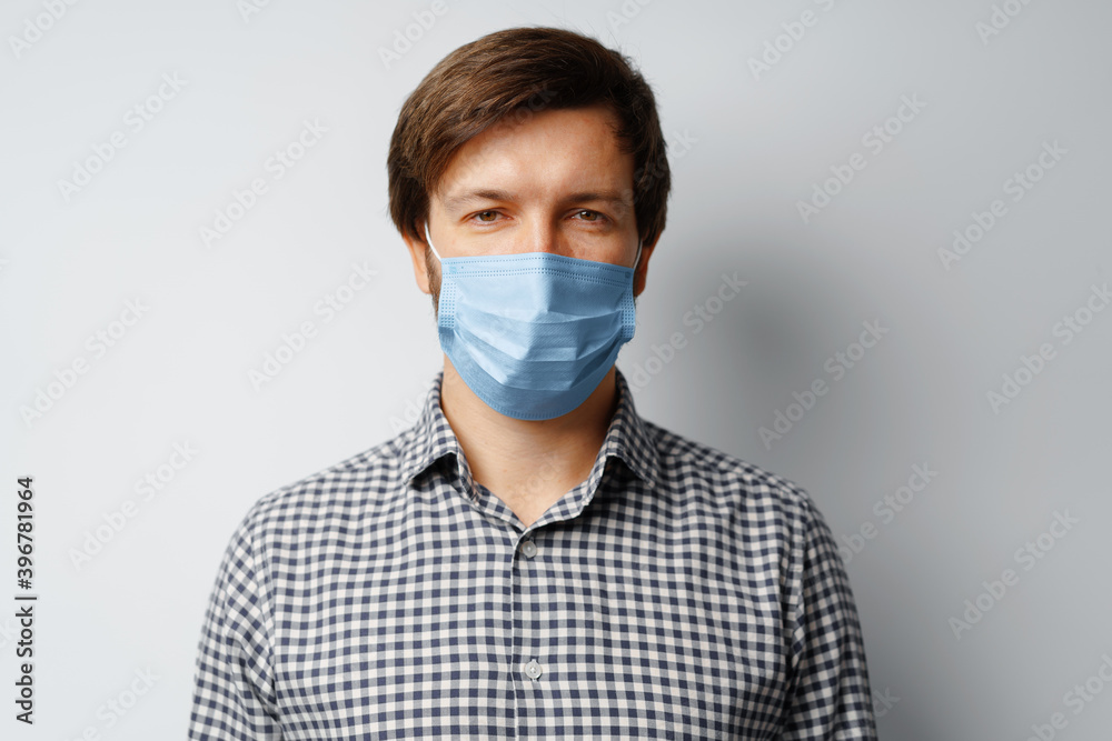 Man wearing hygienic mask against grey background Man wearing hygienic mask against grey background
