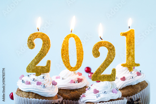 Happy New Year 2021 cupcakes with lighting candles. Merry Christmas and winter season greetings concept. Close up, copy space