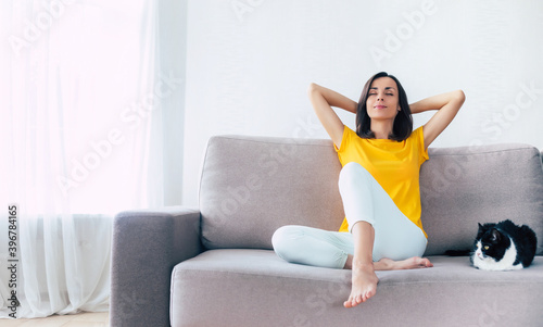 Beautiful calm confident brunette woman is resting on the couch at home during holidays