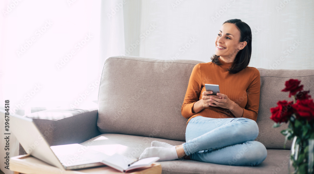 Happy excited beautiful woman with smart phone on the couch Happy excited beautiful woman with smart phone on the couch
