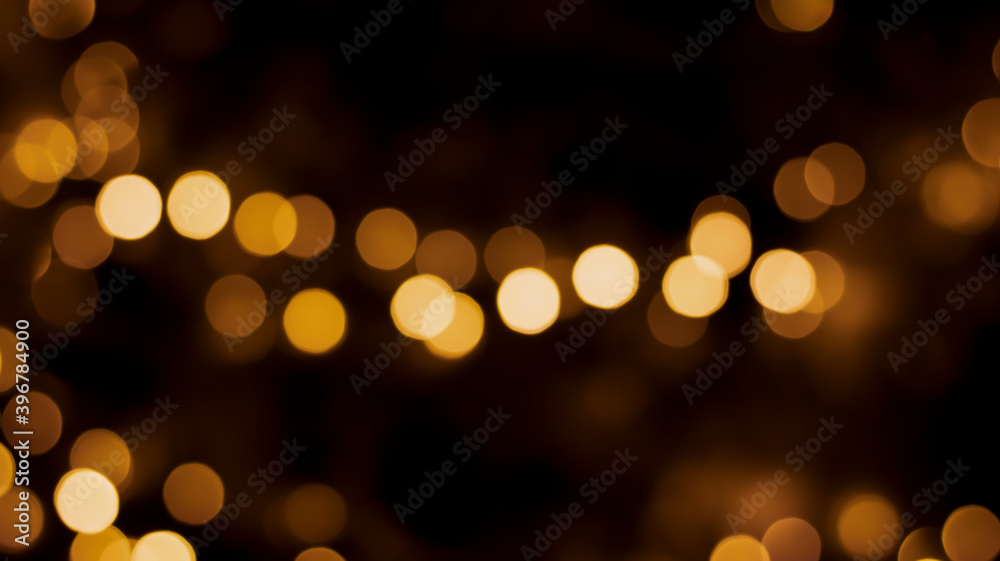Beautiful festive bokeh on a black background golden circles, light night bokeh effect, deflated. Festive postcard, night view.