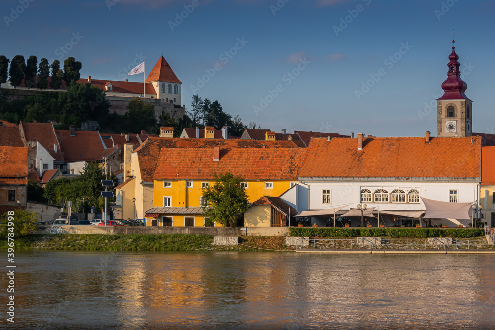 Cityscape of Ptuj with river and church during sunset, Slovenia