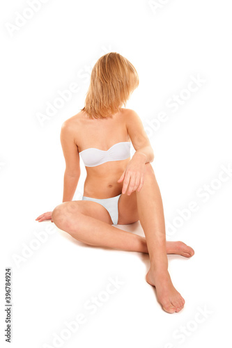 Attractive blonde woman wearing white bra and panties, isolated on white studio background