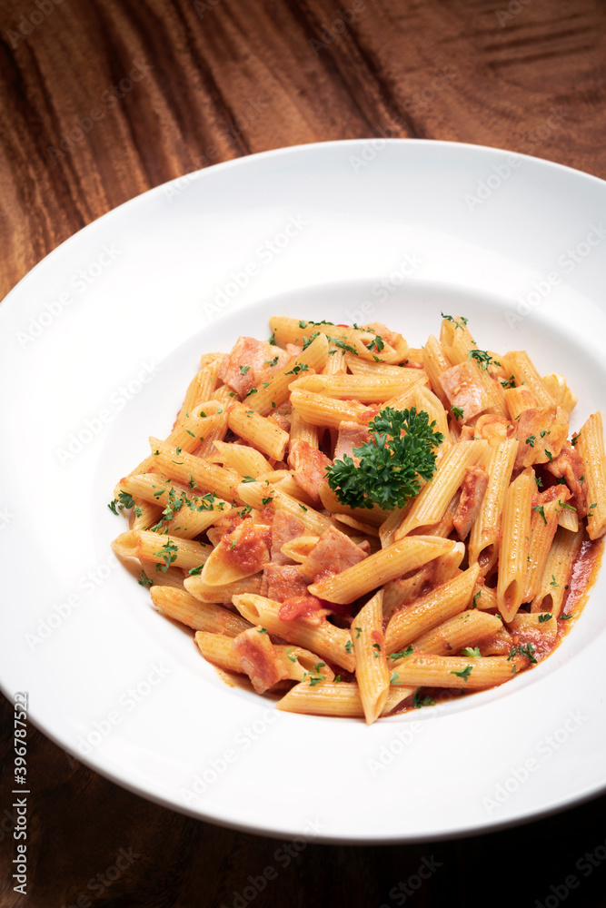 penne amatriciana tomato and ham sauce pasta on wood table penne amatriciana tomato and ham sauce pasta on wood table