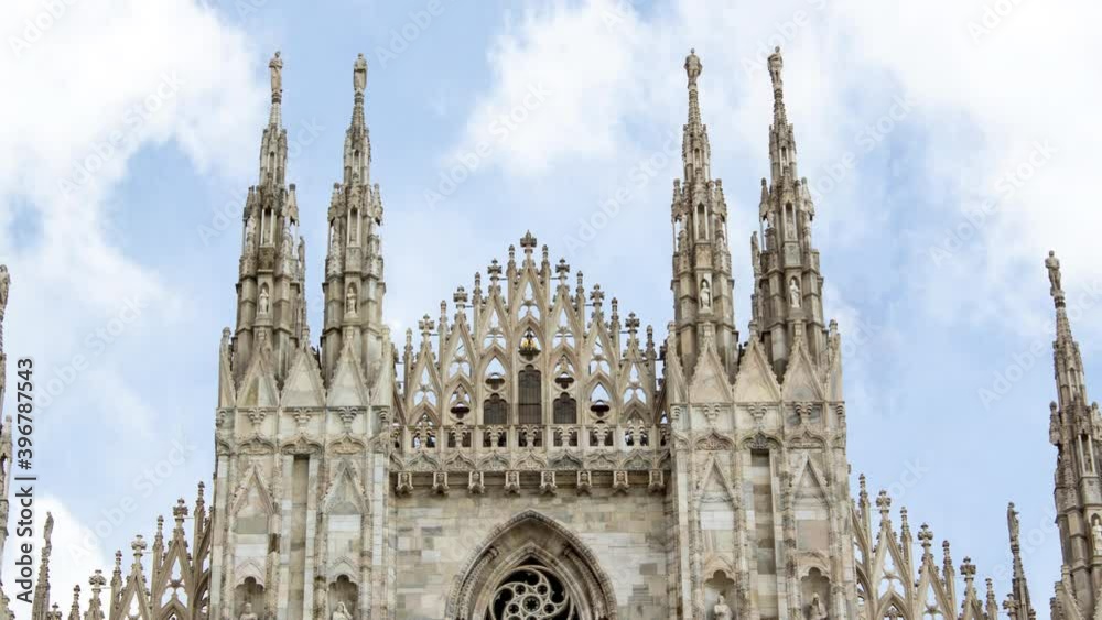 Time lapse of Milan cathedral or duomo di milano during a sunny cloudy day. There is the gothic style church in close up and the clouds in background Time lapse of Milan cathedral or duomo di milano during a sunny cloudy day. There is the gothic style church in close up and the clouds in background