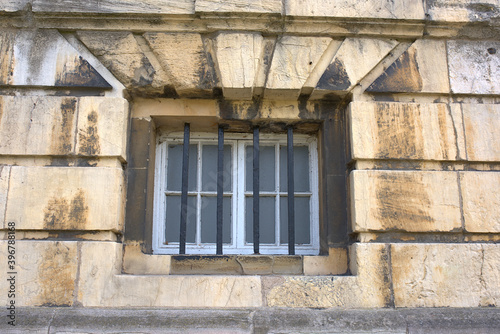 Obraz na płótnie a barred window of a dirty stone wall w salonie