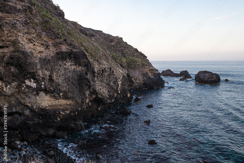 View of the beautiful cliffs with sea waves coming to the shoreline during the evening	
