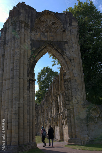 Obraz na płótnie A couple walking through the arch of an ancient ruin w salonie