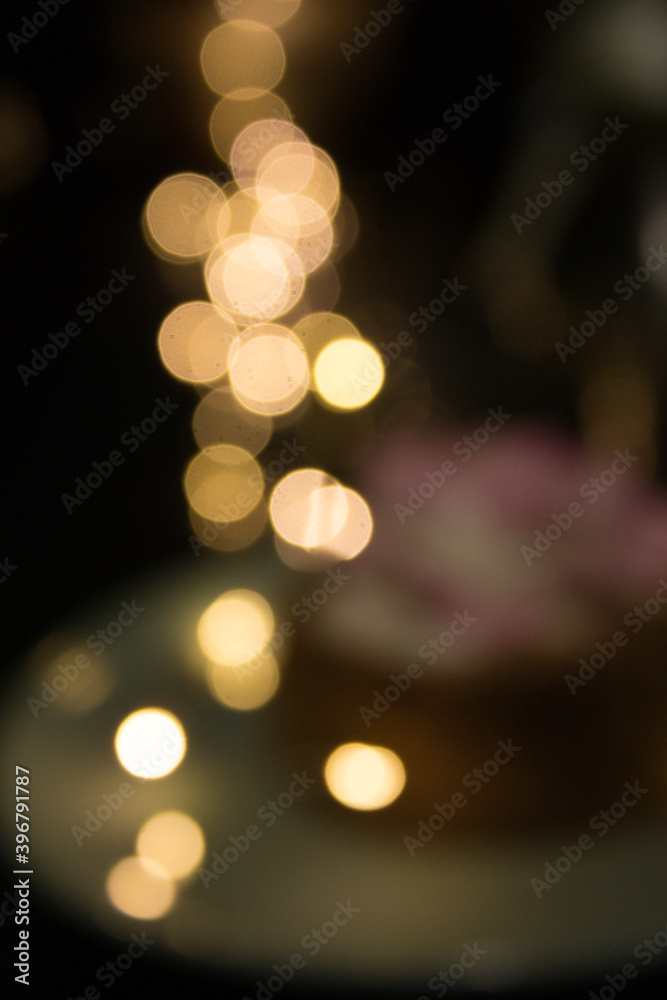 Bokeh in the background and blurred cheesecake on a green plate in the foreground. Bokeh in the background and blurred cheesecake on a green plate in the foreground.