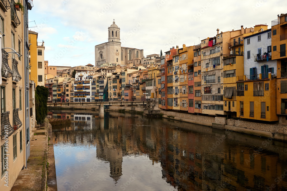 View of the river Onyar and the castle in the city of Girona,.colorful buildings in the historic city center at daytime. Spain.