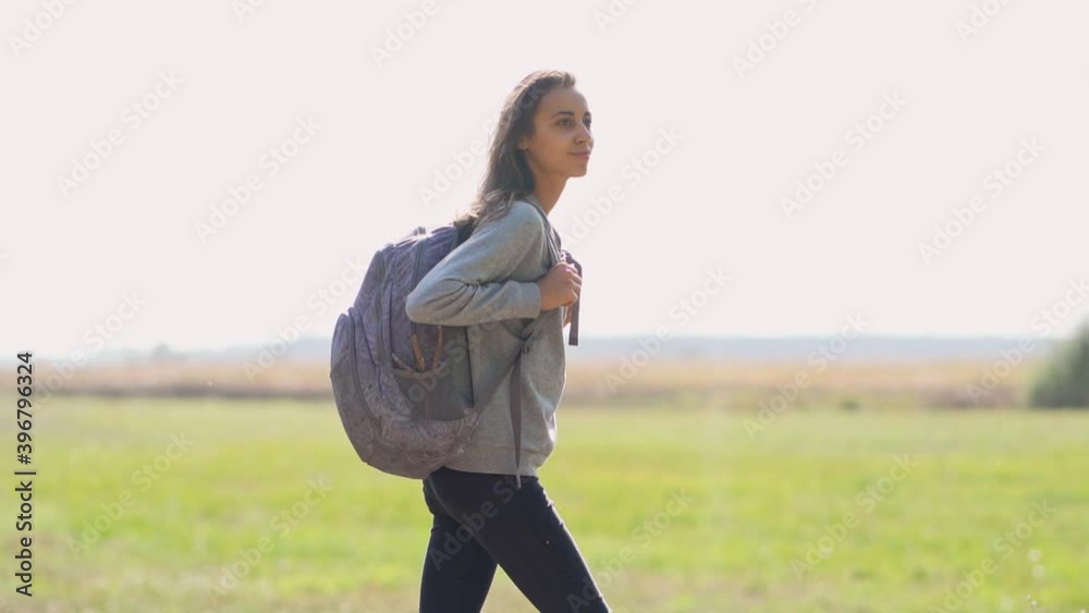 Carefree hipster woman walking in meadow along forest, enjoying fall autumn season. Concept people and nature, outdoors portrait