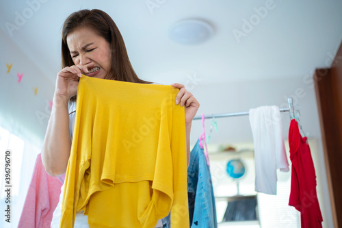 Fotografi Housewife Asian woman is smelly stinky,musty from clothes.