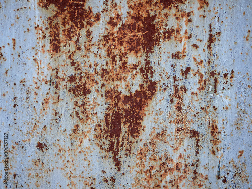 Rust.Old blue painted wall with rust spots.Textured rusty metal background. Rust stains through the cracked blue paint. © Mikhail
