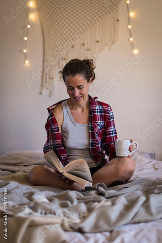Woman relaxing on bed reading book