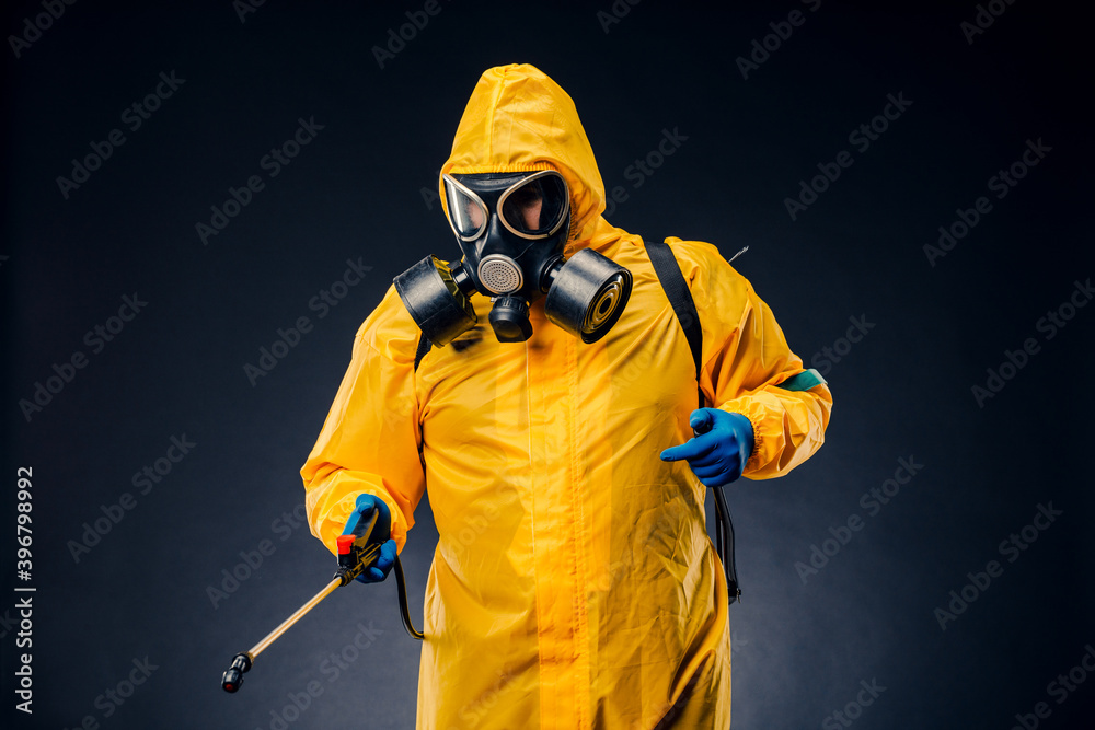Portrait of a man in a yellow chemical protection suit holding a sprayed disinfectant Portrait of a man in a yellow chemical protection suit holding a sprayed disinfectant