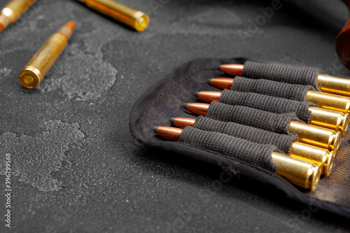 Cartridges for rifle or carbine on dark grey background close up