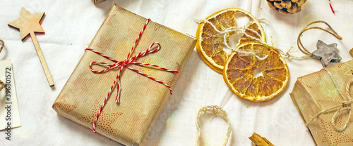 Christmas sustainable gift box. Christmas zero wast.Components for sustainable packaging paper, cones, fabric, spices, dried oranges, twine on a light table