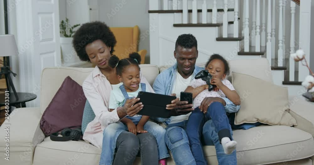 Front view of beautiful happy loving cheerful african american family which having fun together at home while revisioning funny videos on tablet pc ,4k Front view of beautiful happy loving cheerful african american family which having fun together at home while revisioning funny videos on tablet pc ,4k