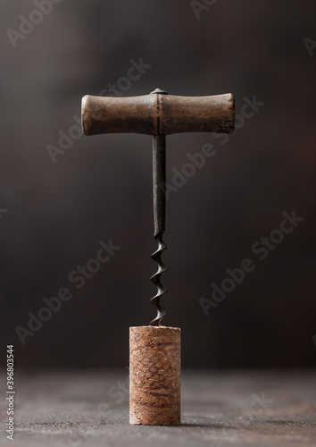 Fotografie Wine cork with vintage corkscrew on top on wood background.