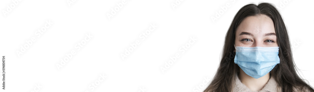 Young girl in mask in white background. Mask protects you and your health. Coronavirus Pandemic. copy space. banner Young girl in mask in white background. Mask protects you and your health. Coronavirus Pandemic. copy space. banner