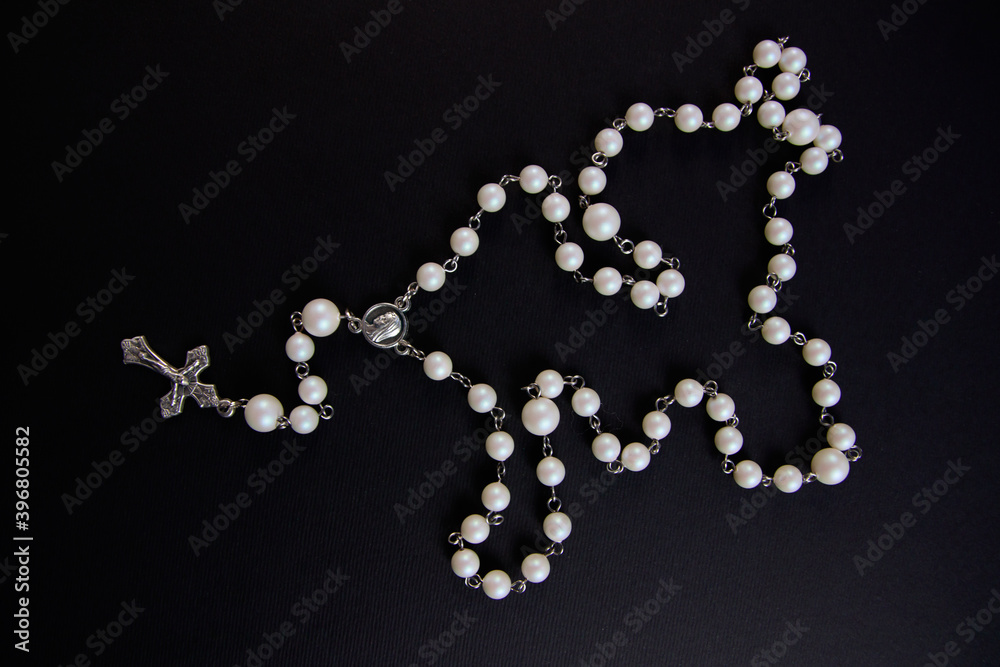 White rosary on black background, view from above White rosary on black background, view from above