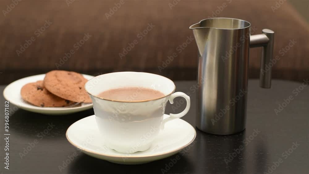 Coffee with milk. Milk is poured into freshly brewed, hot coffee, from which steam rises. Coffee with milk. Milk is poured into freshly brewed, hot coffee, from which steam rises.