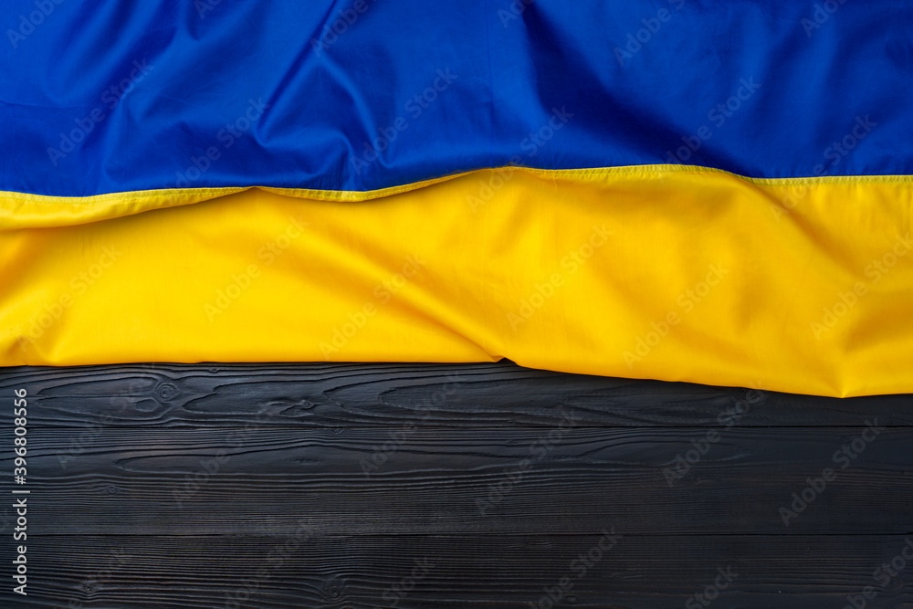 Fototapeta premium National flag of Ukraine on dark wooden background