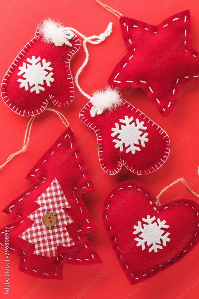 Background from textile Christmas tree toys on a red background, top view Background from textile Christmas tree toys on a red background, top view