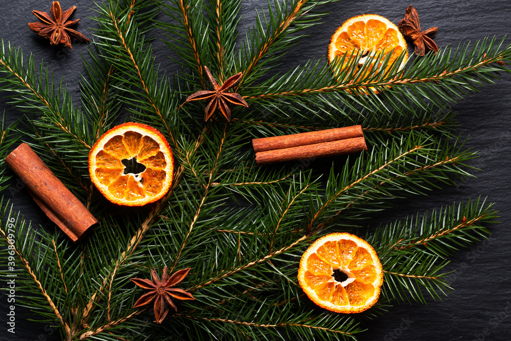 Seasonal background concept Winter or Christmas spices and pine leave on black slate stone board with copy space Seasonal background concept Winter or Christmas spices and pine leave on black slate stone board with copy space
